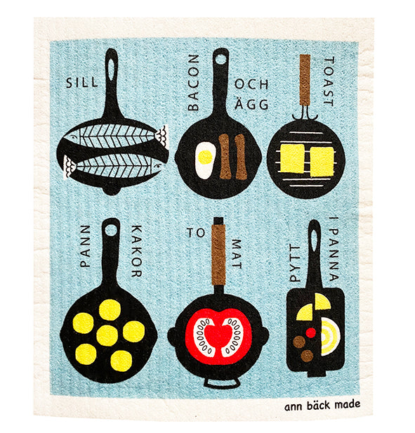 A cheerful Finnish dishcloth featuring playful frying pans on a bright blue background. The pans are filled with colorful vegetables, hash, and toast, creating a fun and cozy kitchen motif perfect for everyday use. disktrasa med stekpannor med blå bakgrund.Suomalainen tiskiliina paistinpannuilla kirkkaalla sinisellä taustalla